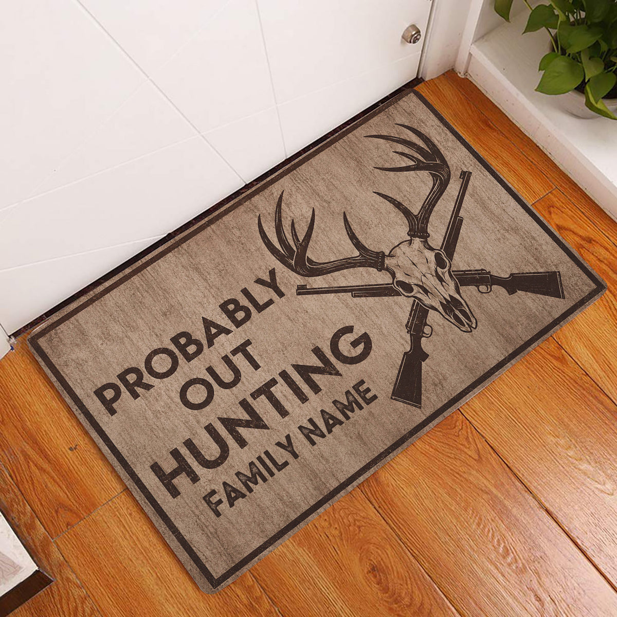 Rustic hunting doormat displayed at an indoor entryway beside a white door and hardwood floor
