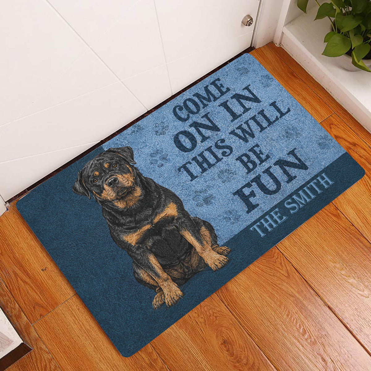 Rottweiler welcome doormat styled in a home entryway on a warm wood floor beside a door