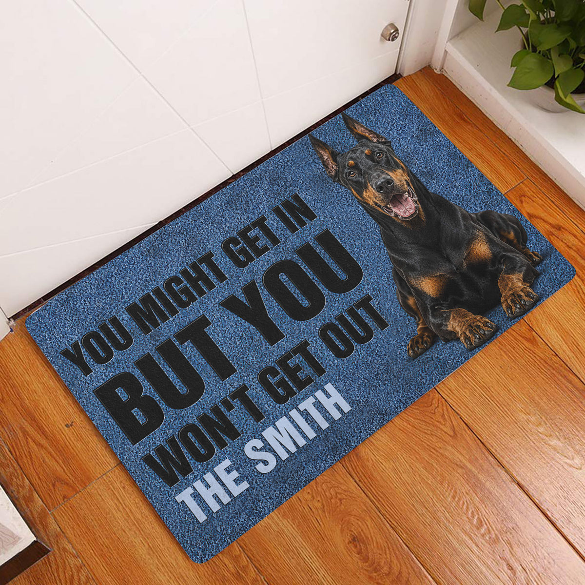 Blue Doberman doormat displayed at a home entryway on a warm wood floor