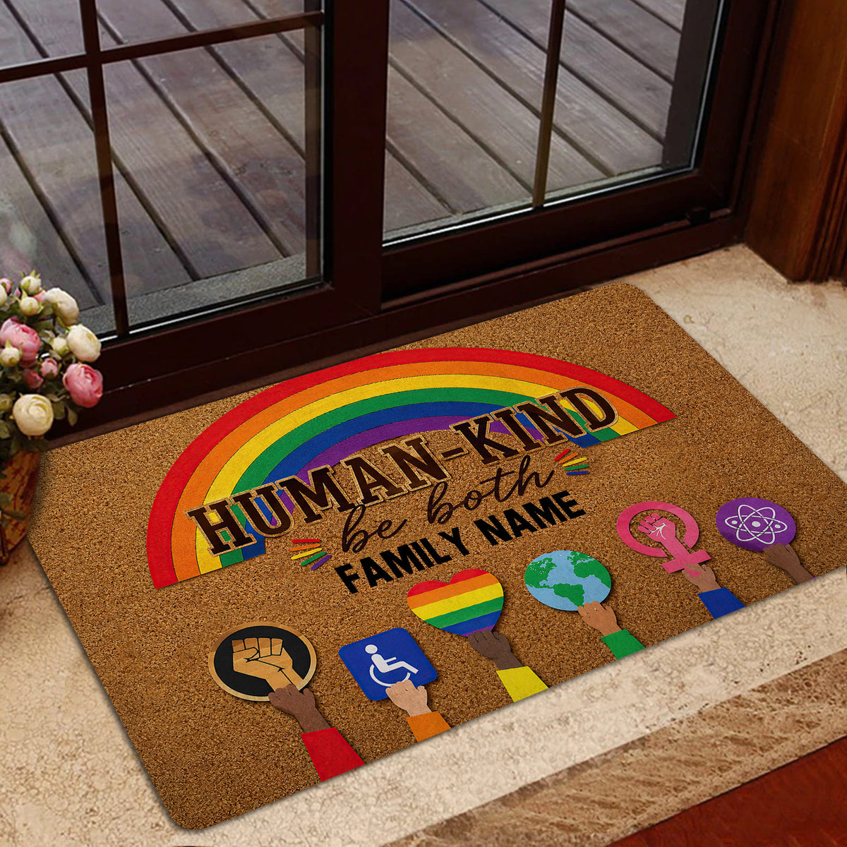 Rainbow pride doormat styled inside a glass doorway with a warm, welcoming design