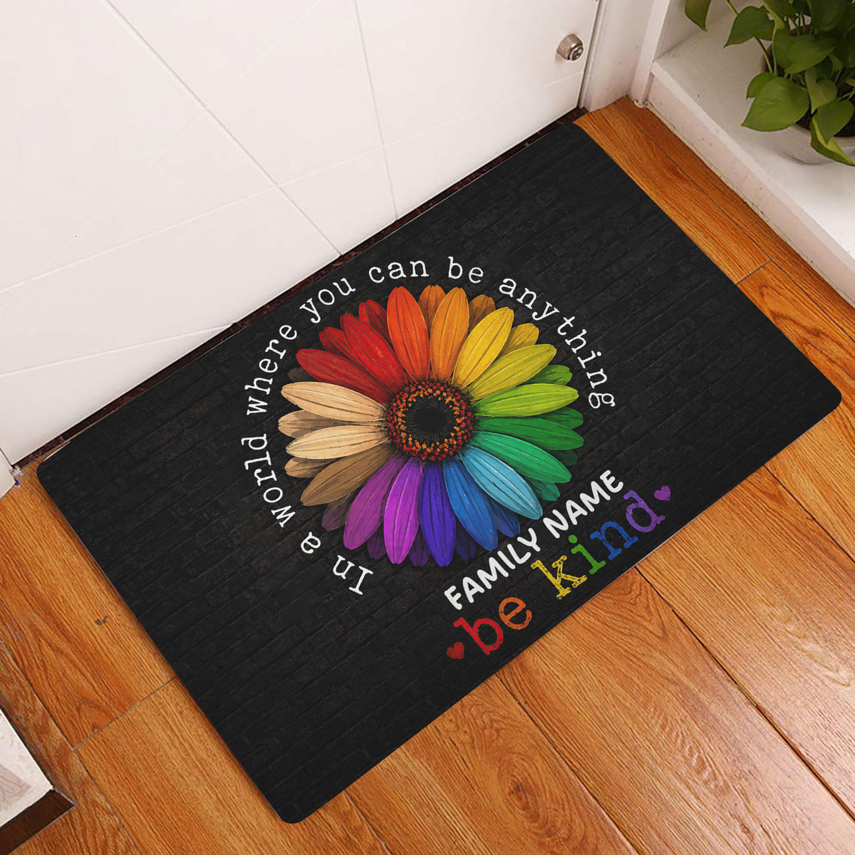 Rainbow LGBT doormat displayed in a bright indoor entryway beside a white door