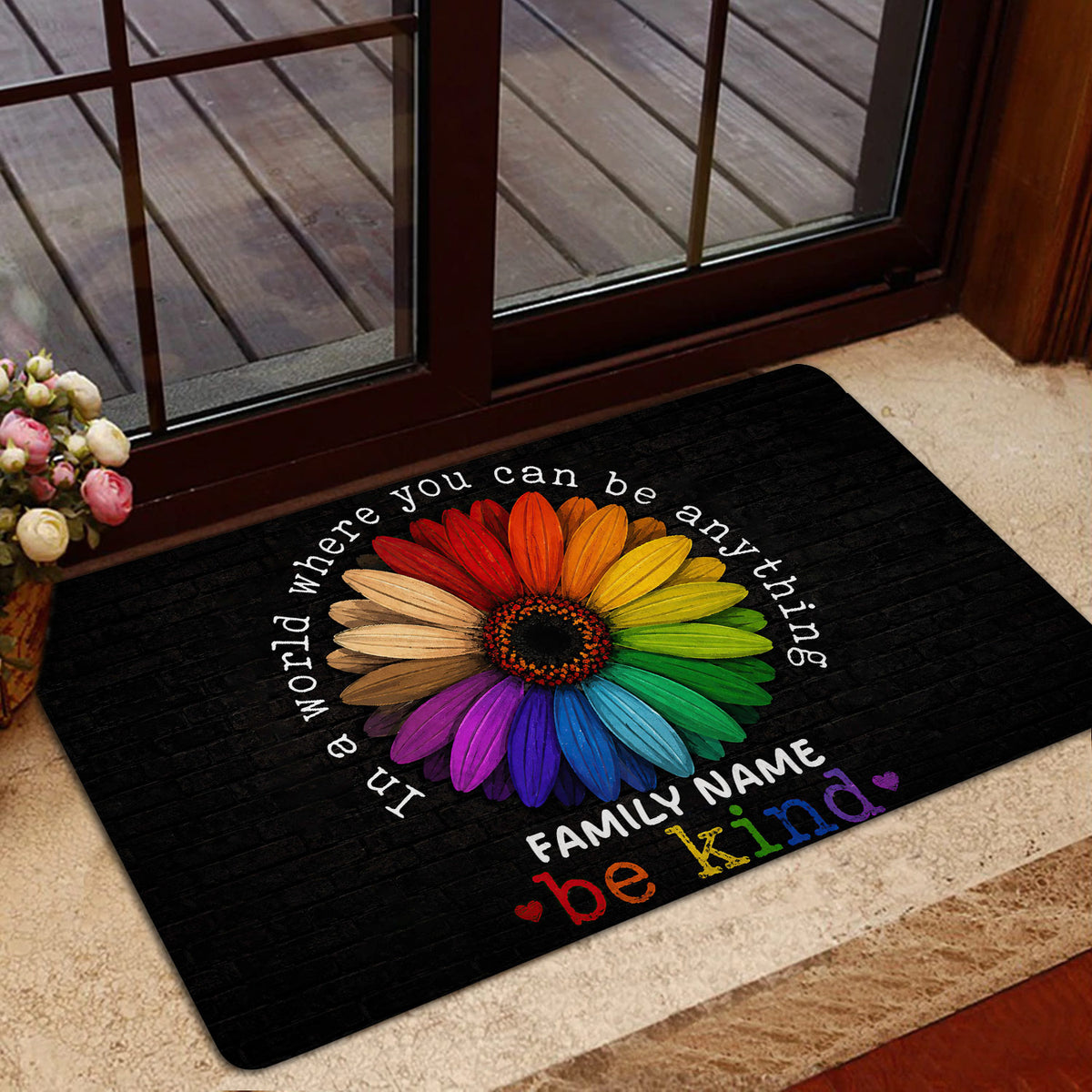 Rainbow flower LGBT doormat shown in a welcoming doorway with wood and glass doors