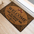 Wine welcome door mat with red wine glasses and ornate scrollwork beside an interior doorway