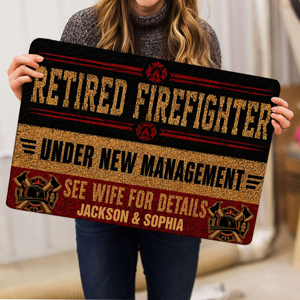 Firefighter doormat held indoors, showing bold fire service artwork, equipment emblems, and decorative borders