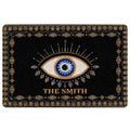 Black evil eye doormat with a large blue and gold eye motif and ornate geometric border
