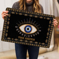 Evil eye doormat held indoors, showing the large central eye and detailed border