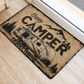 Rustic camping door mat placed at an entrance, showing a travel trailer, mountains, and pine trees