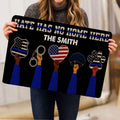 Person holding a police-themed doormat featuring badge, handcuffs, police hat, paw artwork, and patriotic blue-line colors