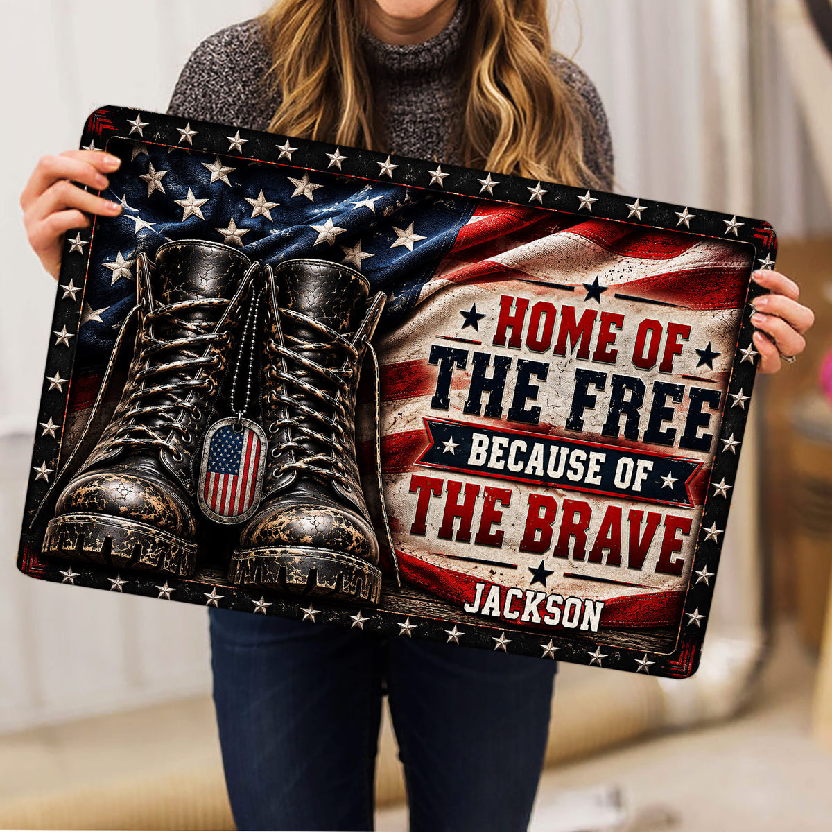Person holding a patriotic veteran doormat featuring combat boots, stars, and flag-inspired artwork