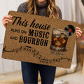 Bourbon-themed entryway mat held indoors, featuring whiskey, record, and music artwork