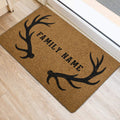 Hunting-themed entryway rug with black antlers and family lettering near a doorway