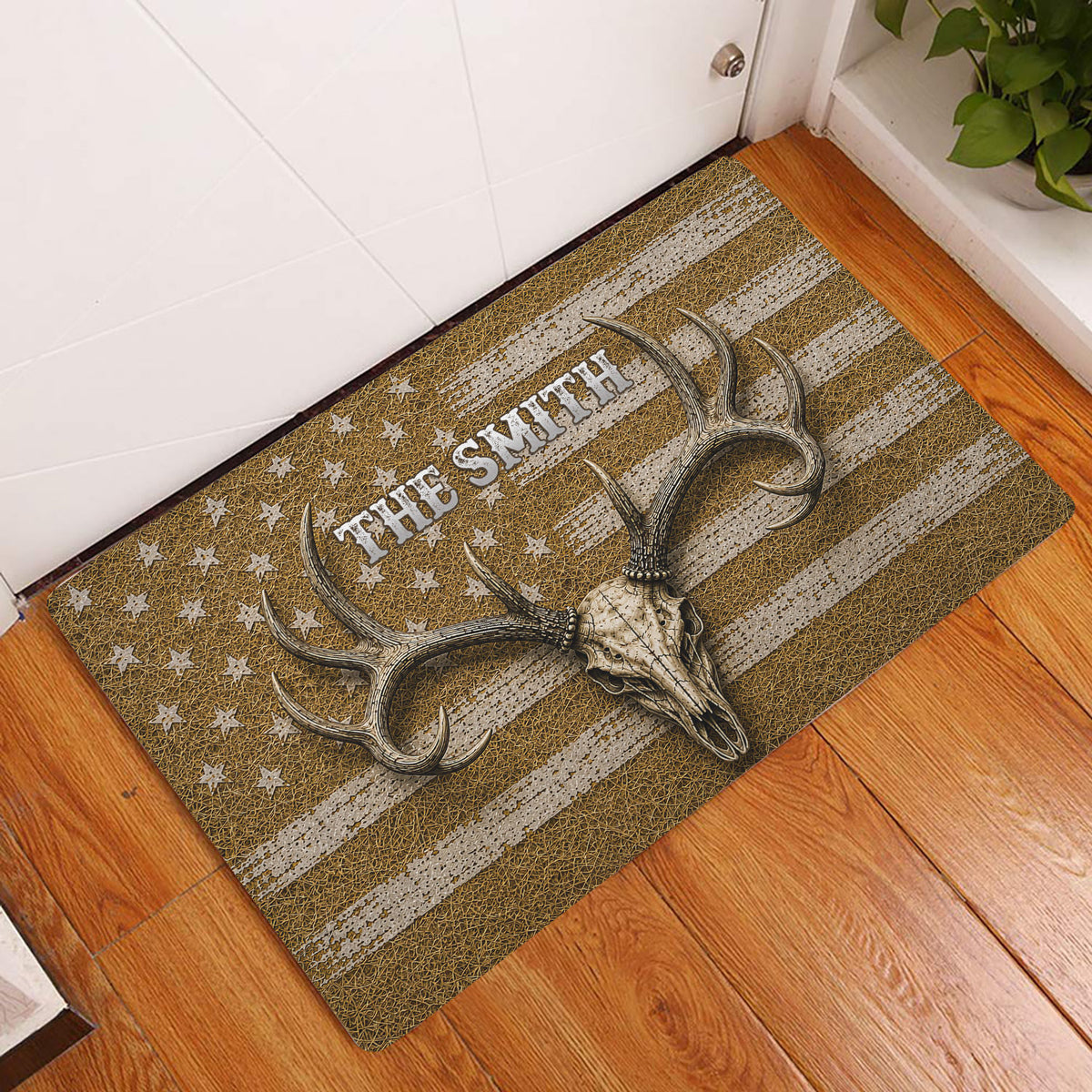 Hunting-themed doormat displayed in an indoor entryway on hardwood flooring with a deer skull and antlers design