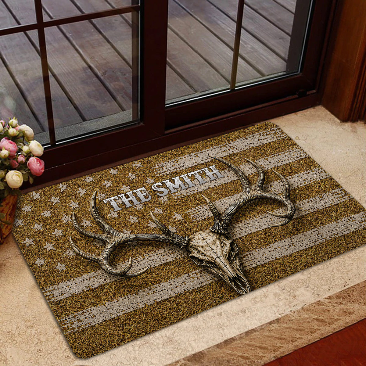 Hunting doormat with antlered skull artwork shown in a home entrance beside a glass door and wood deck