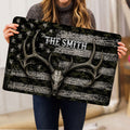 Person holding a hunting doormat featuring a deer skull, antlers, camouflage and star details