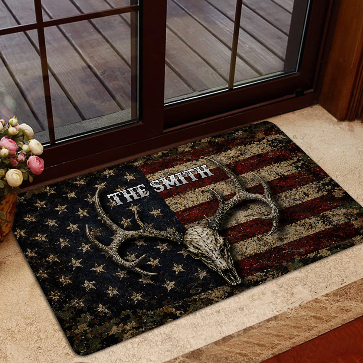 Patriotic hunting doormat featuring an antlered deer skull displayed near a glass door and wood deck