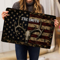 Hunting doormat held indoors showing a deer skull, large antlers, stars, stripes and rustic artwork