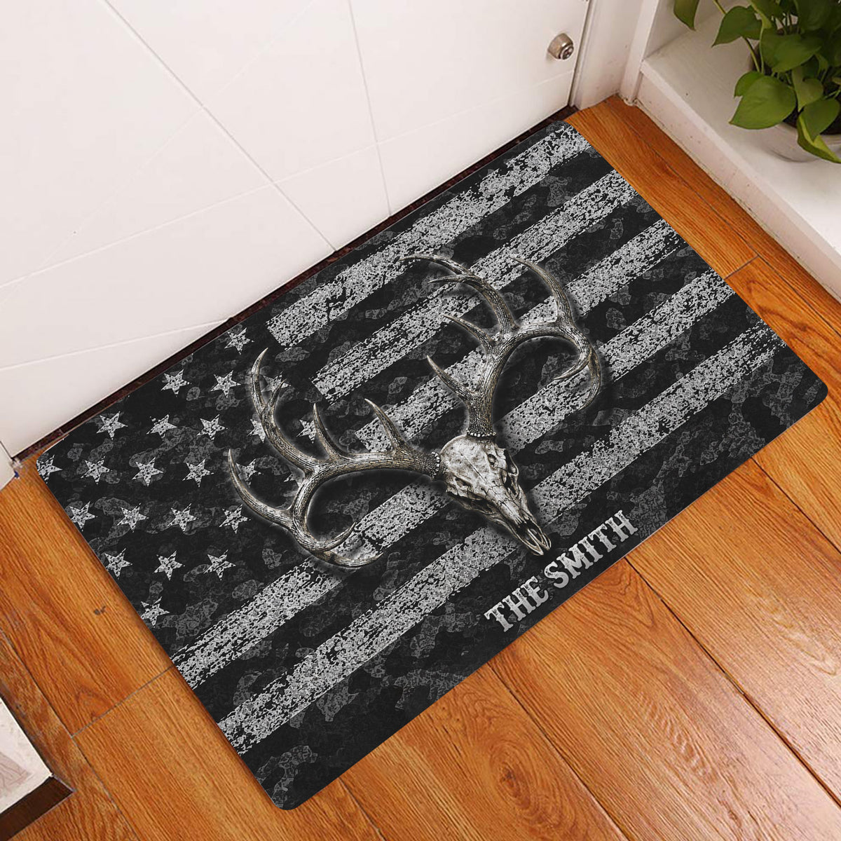 Deer skull hunting doormat displayed in an entryway on warm wood flooring beside a white door