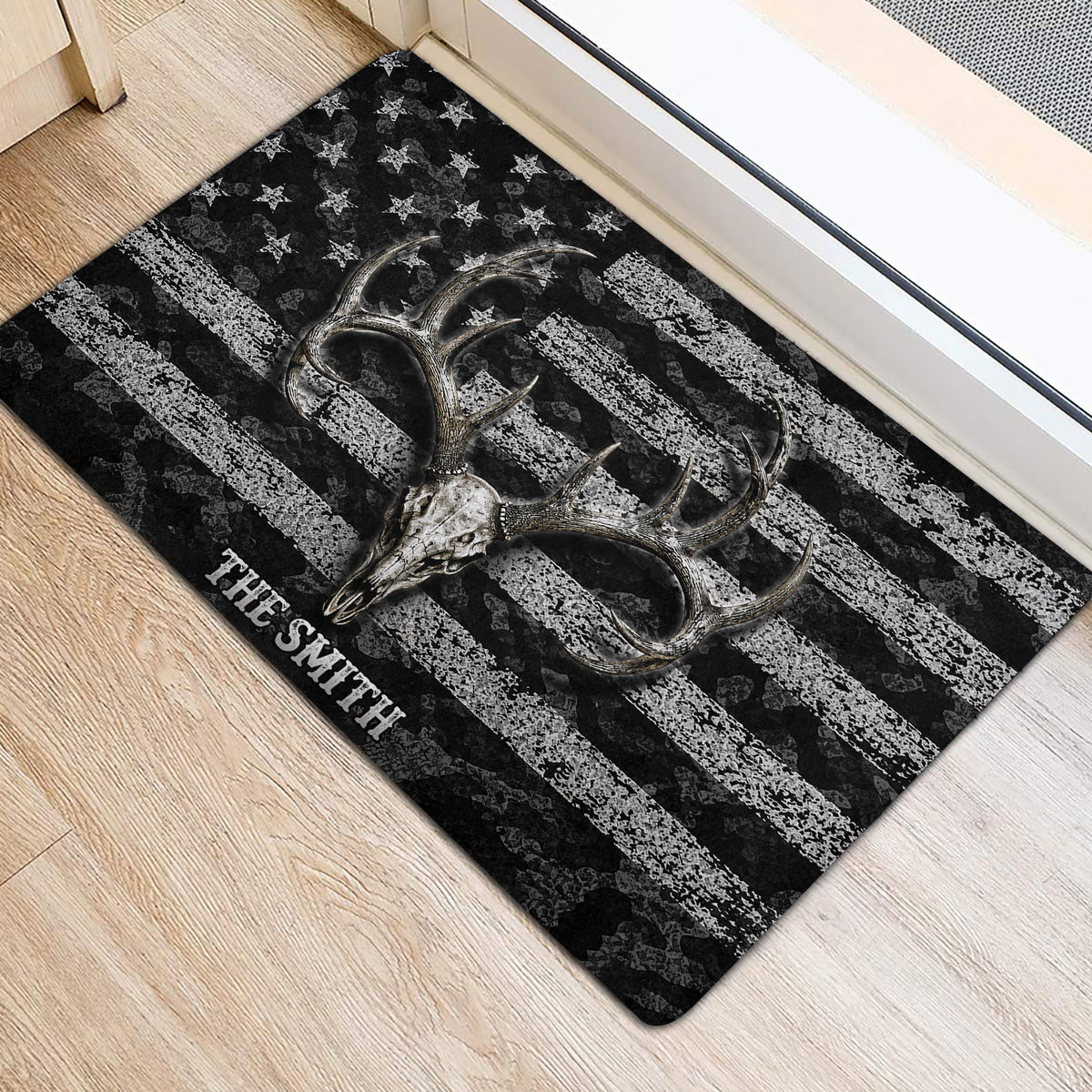Hunting-themed deer skull and antler doormat placed inside a doorway on a light wood floor