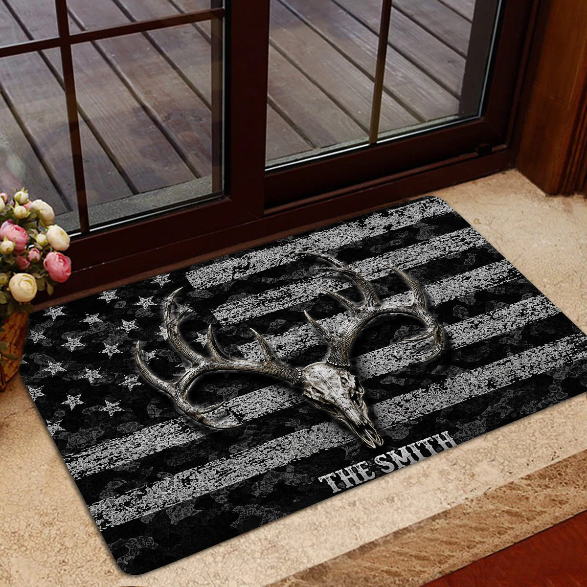 Deer skull hunting doormat styled at a glass entry door with a deck visible outside