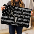 Lifestyle view of a person holding a hunting doormat featuring a deer skull and antler design