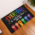 Rainbow LGBT welcome doormat displayed in a bright home entryway on a wood floor