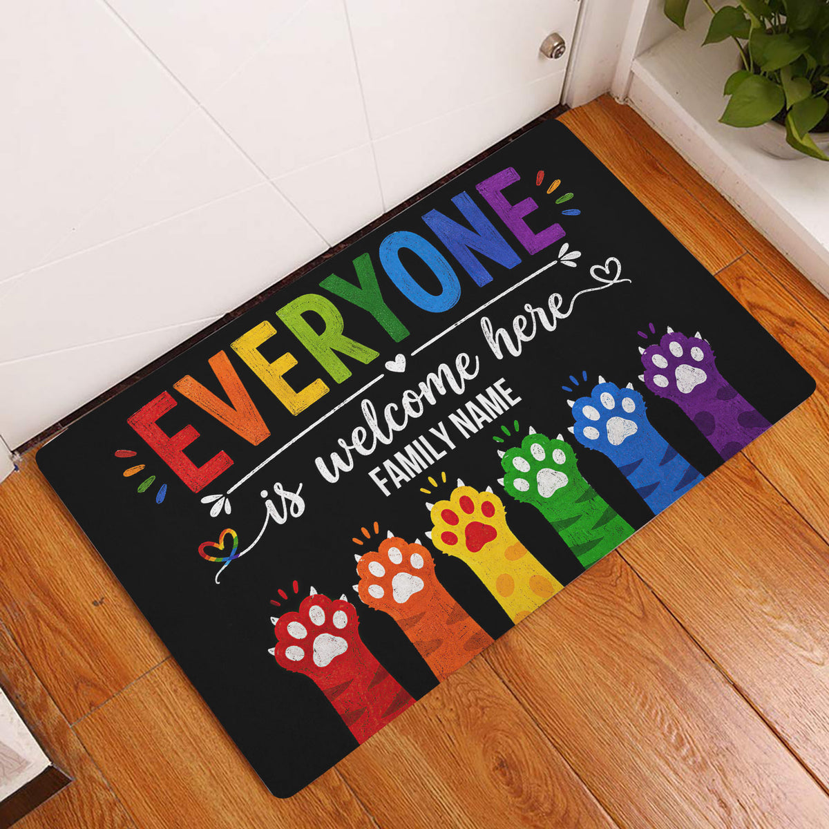 Rainbow LGBT welcome doormat displayed in a bright home entryway on a wood floor