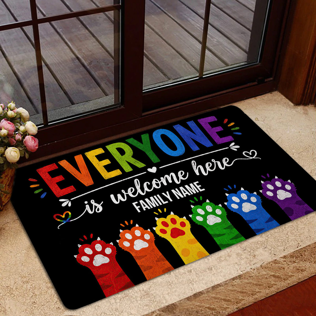 Rainbow LGBT welcome mat styled near a glass entrance door with colorful paw prints and inclusive artwork