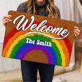 Rainbow Pride doormat held indoors, showing the bright Welcome artwork and colorful arc