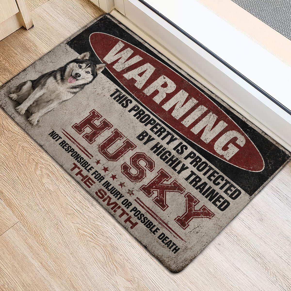 Husky door mat positioned beside a bright entry door on light wood flooring
