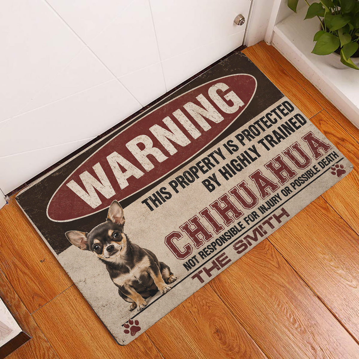 Chihuahua warning design doormat displayed beside a white door on a warm wood floor