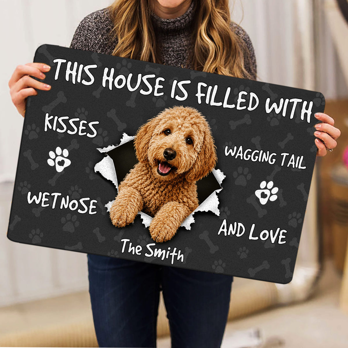 Person holding a Goldendoodle doormat featuring a curly dog portrait, paw prints and playful lettering