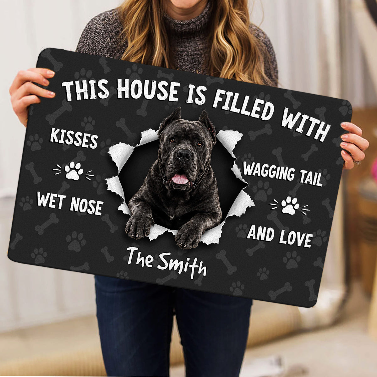 Cane Corso doormat held indoors, showing the dog portrait, paw prints and bone pattern
