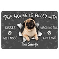Pug doormat with a smiling pug, bones, paw prints and playful welcome message on a dark background