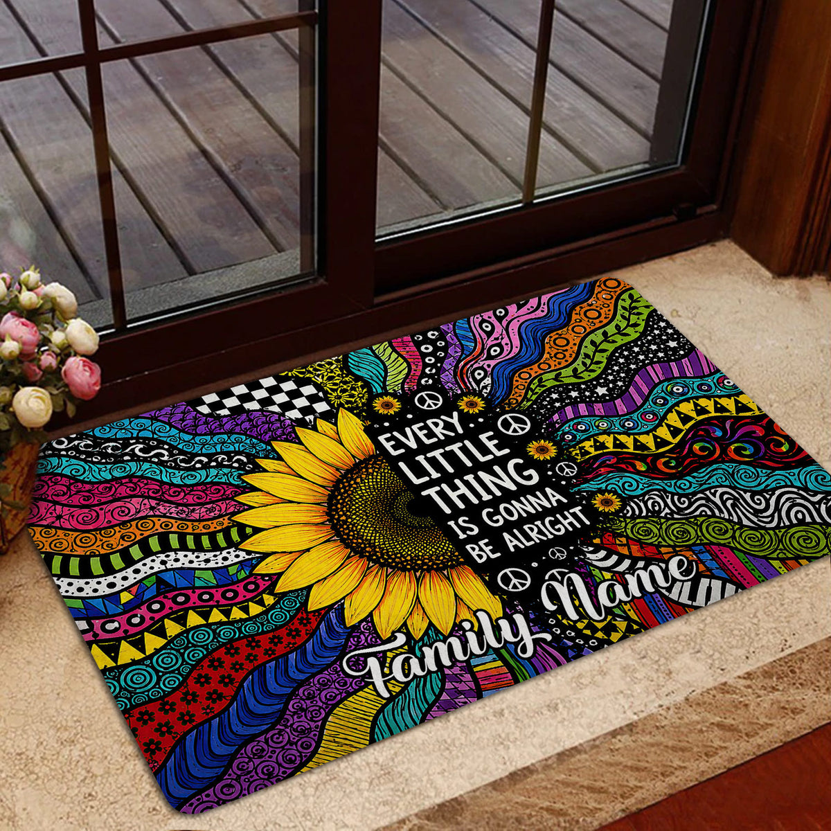 Vibrant hippie doormat with sunflower and peace symbols placed by a glass door in a home entryway