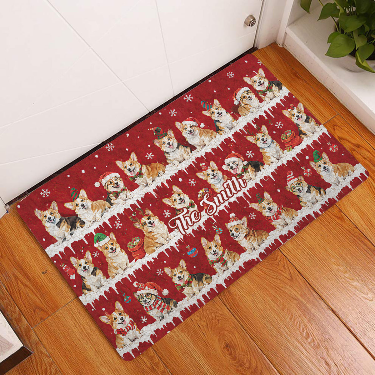 Festive corgi doormat displayed at a home entrance on hardwood flooring with snowy red Christmas artwork