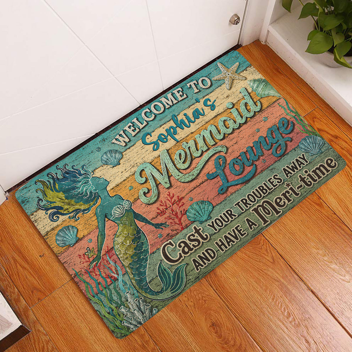 Mermaid entryway rug displayed beside a white door on a warm wood floor