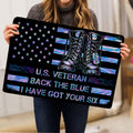 Person holding a veteran doormat featuring military boots, stars, and vibrant flag-inspired artwork