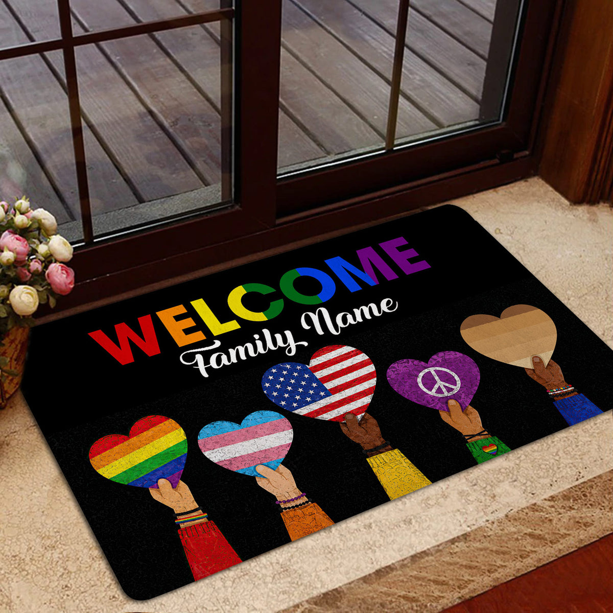 LGBT pride welcome mat displayed at a home entrance with colorful hearts and inclusive artwork