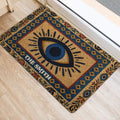 Blue and gold evil eye door mat positioned beside a bright indoor doorway