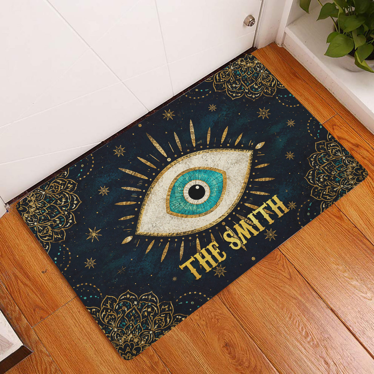 Evil eye entryway mat displayed beside a white door on warm wood flooring