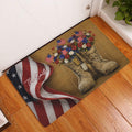 Patriotic veteran rug displayed at a home entrance with combat boots, flags, flowers, and a folded American flag