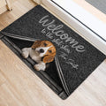 Beagle doormat displayed beside a doorway with a playful welcome message and rustic doghouse design