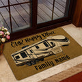 Golden camping door mat with a travel trailer design placed by a glass entry door