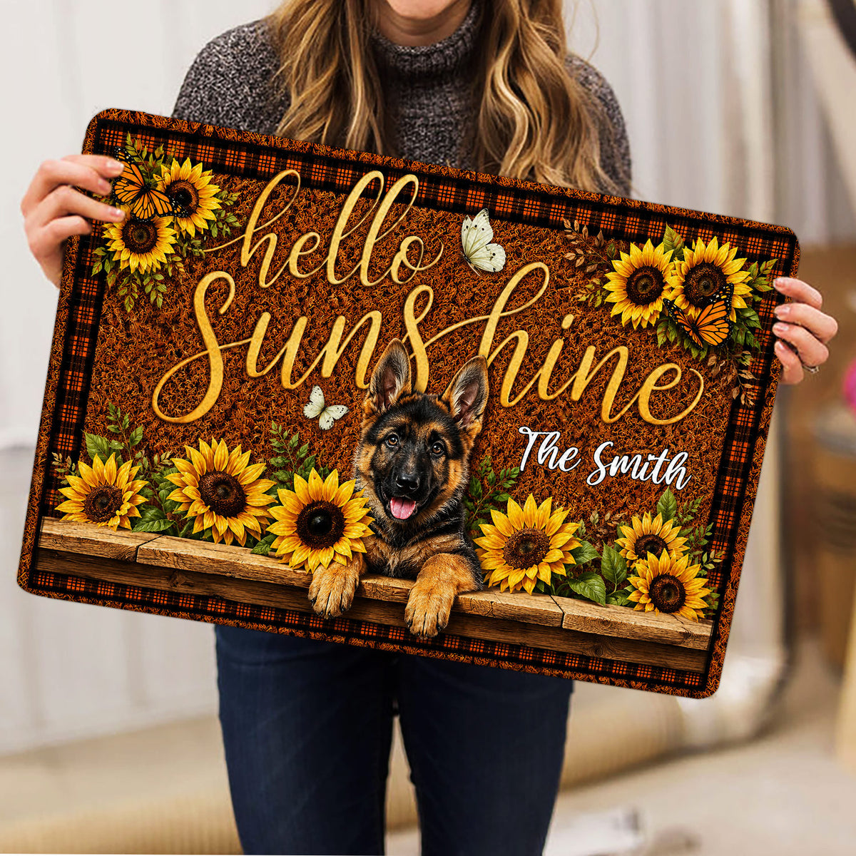 Person holding a German Shepherd doormat featuring sunflowers, butterflies and a rustic welcome design