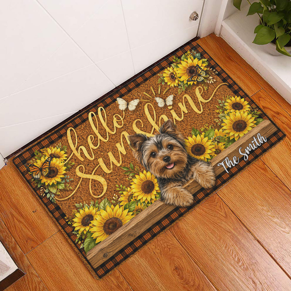 Yorkie sunflower doormat displayed at an indoor entryway beside a white door and wood flooring