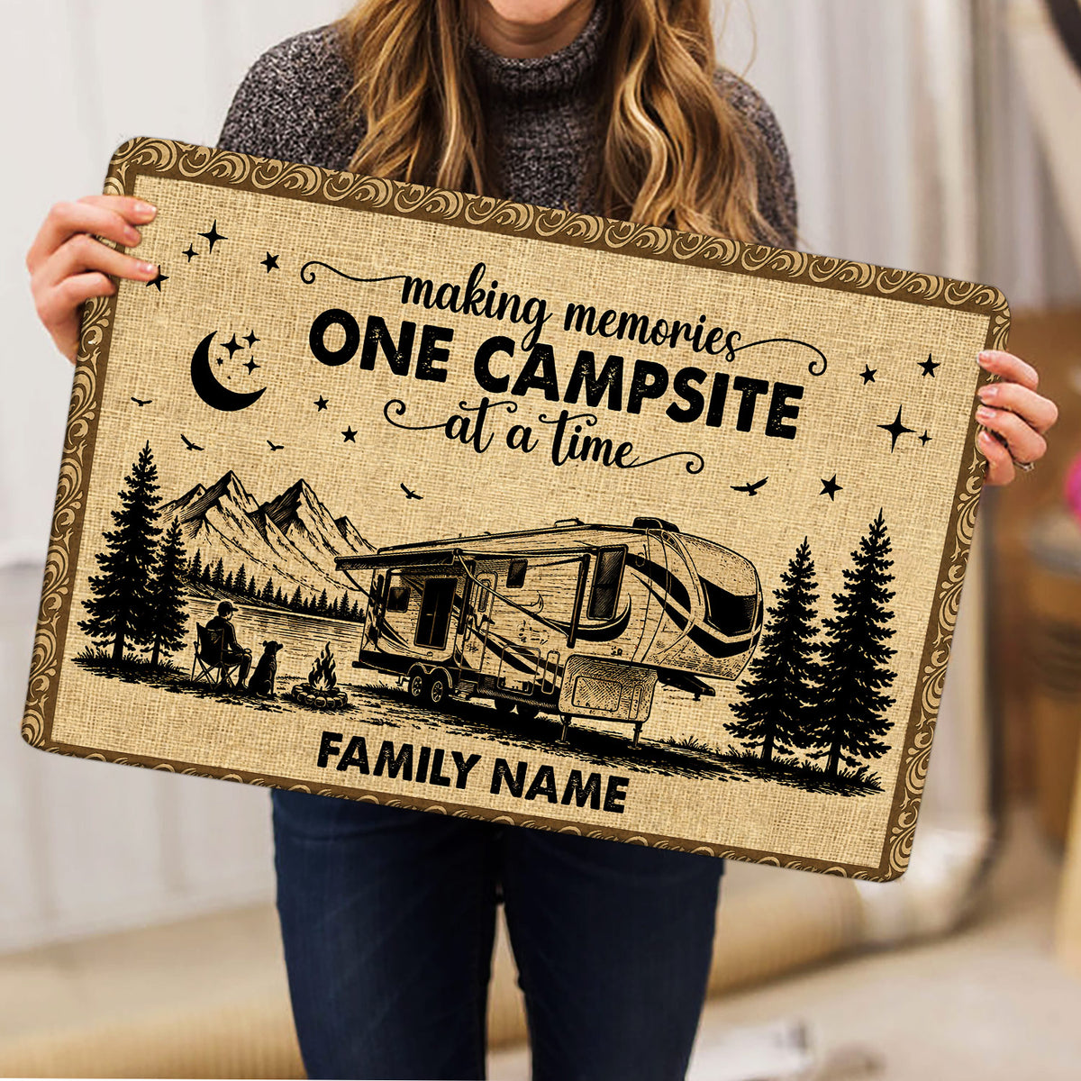 Camping-themed doormat held indoors, showing an RV beside mountains, pine trees, stars, and a campfire