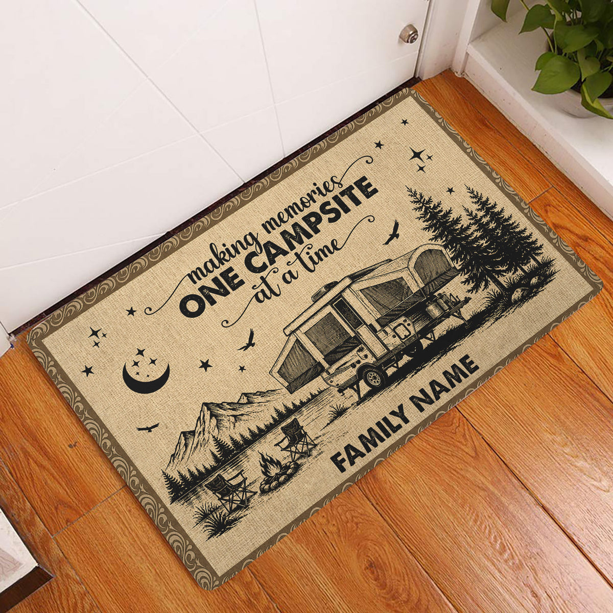 Camping entryway rug displayed on a wood floor beside a door with a mountain and camper scene