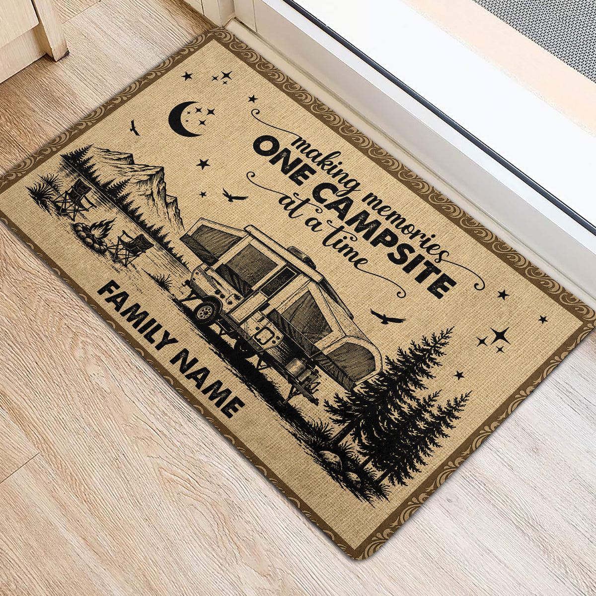 Rustic camping door mat placed near an entrance, featuring an RV, mountains, trees, stars, and campfire artwork