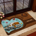 Rustic camping doormat placed near a glass door, featuring a motorhome, campfire emblem, and welcoming travel theme