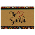 African-inspired geometric doormat with warm tan center, colorful patterned borders, and heart artwork